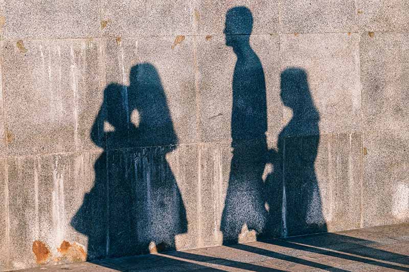 Picture of the shadow of a family walking in front of a wall