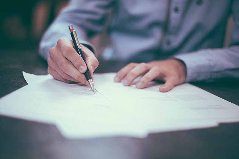 Picture of a lawyers hands signing documents