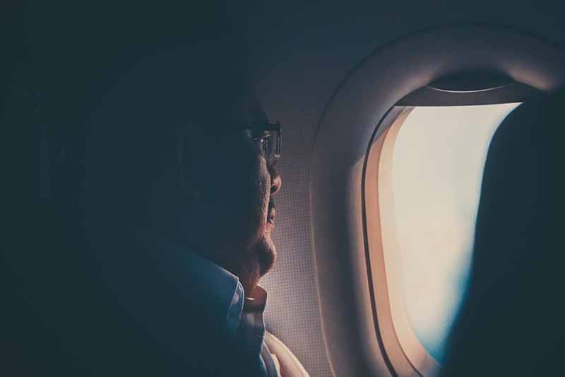 Picture of a man gazing out the window of an aeroplane