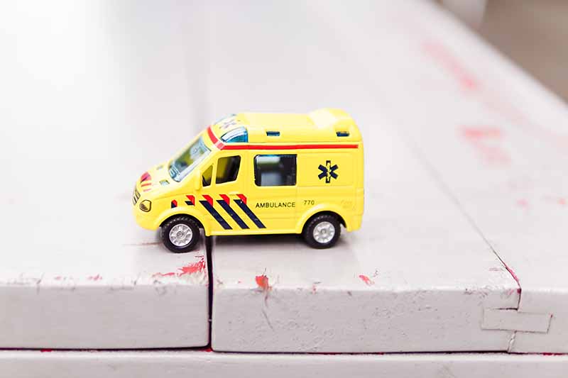 Picture of toy ambulance sitting on a park bench