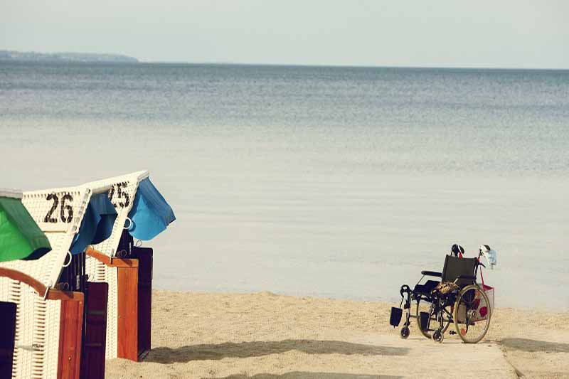 Picture of wheelchair at the beach with coloured beach houses